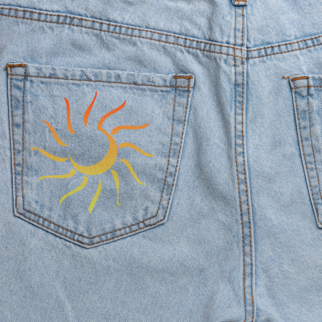 Custom DTF print service featuring a vibrant sun design on the back pocket of denim shorts