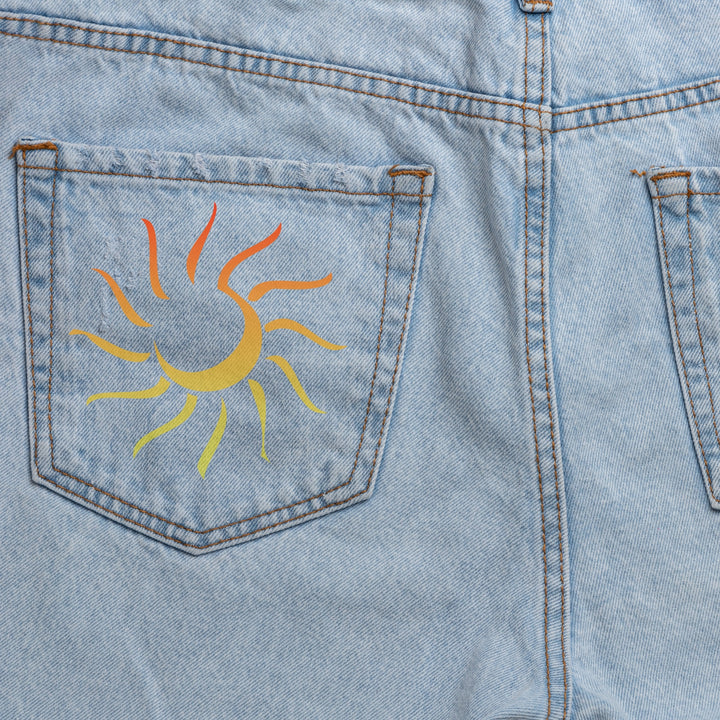 Custom DTF print service featuring a vibrant sun design on the back pocket of denim shorts