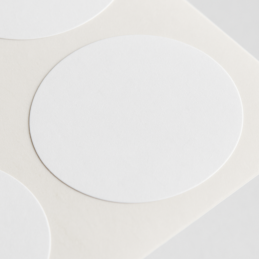 Close-up of blank white customizable sticker sheets with round cutouts for custom printing