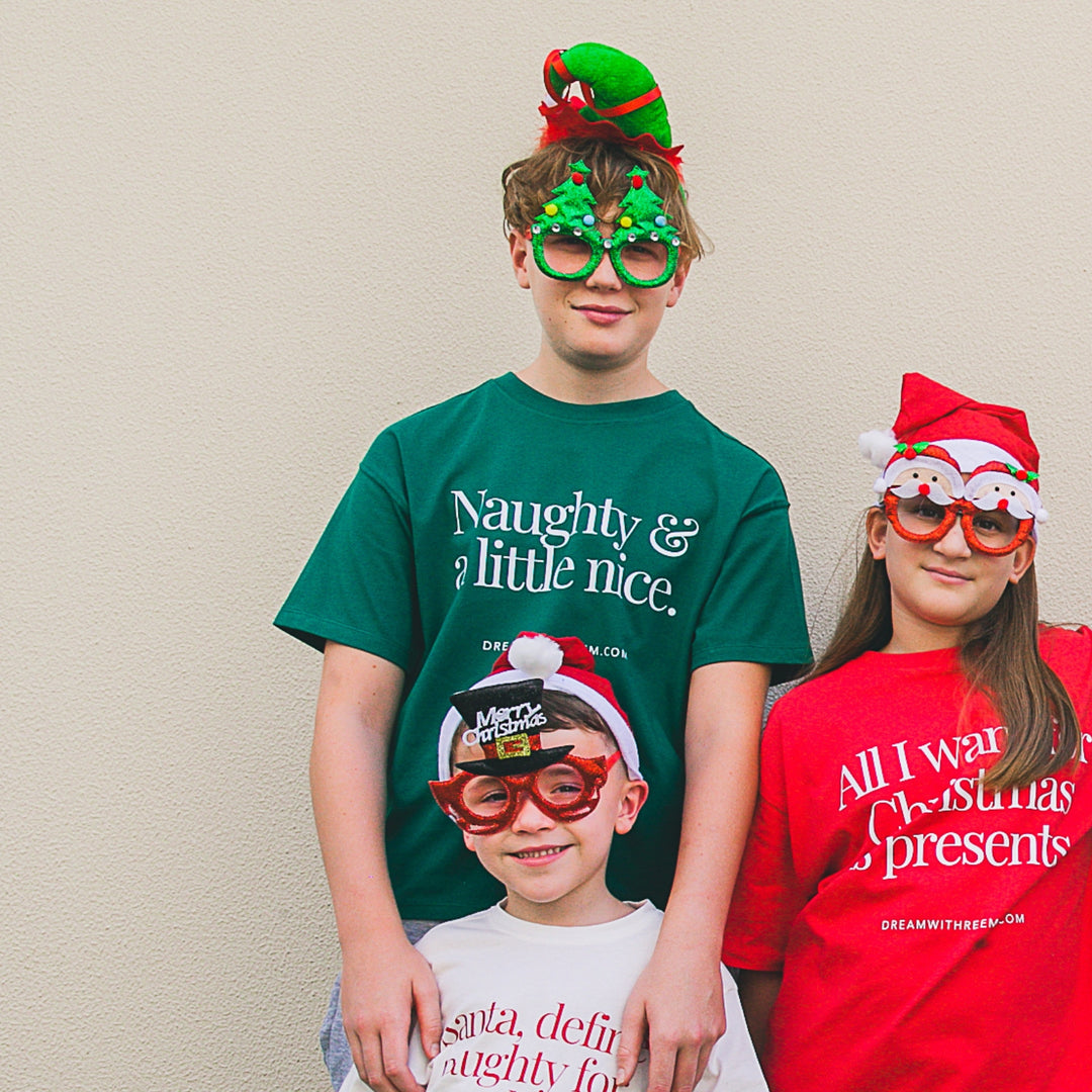 Teens wearing a Funny Christmas shirt for teens with festive hats and glasses, celebrating the holiday spirit