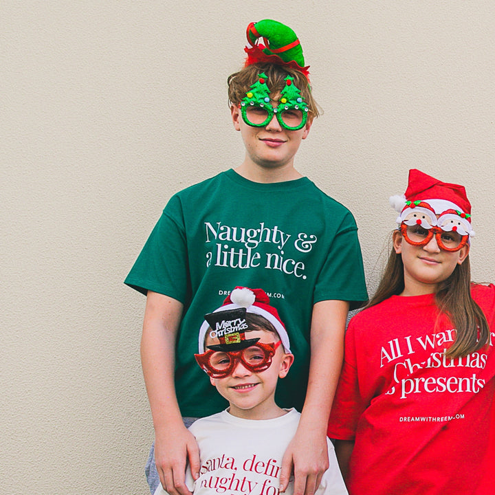 Teens wearing a Funny Christmas shirt for teens with festive hats and glasses, celebrating the holiday spirit