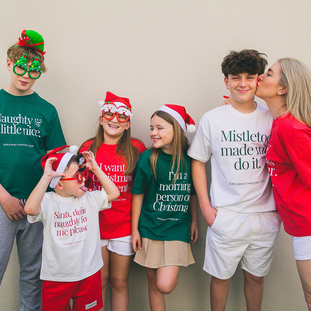 Holiday party graphic tee collection featuring festive designs on cheerful participants wearing Christmas attire