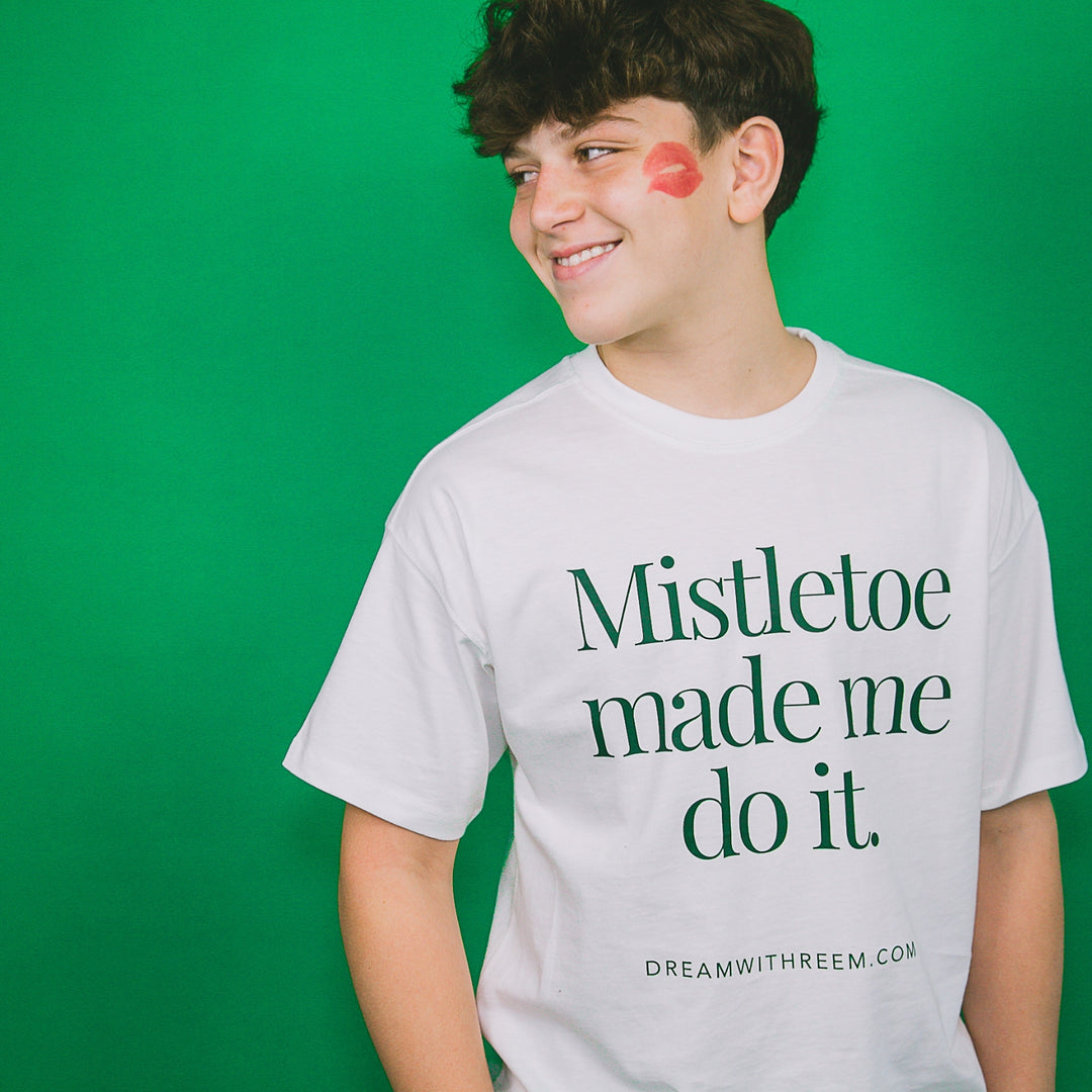 Custom holiday party graphic tee with 'Mistletoe made me do it' text for festive celebrations
