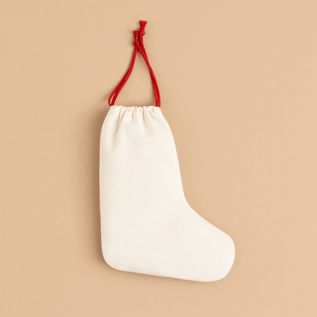 Personalized holiday stocking in off-white with red drawstring for festive decorations