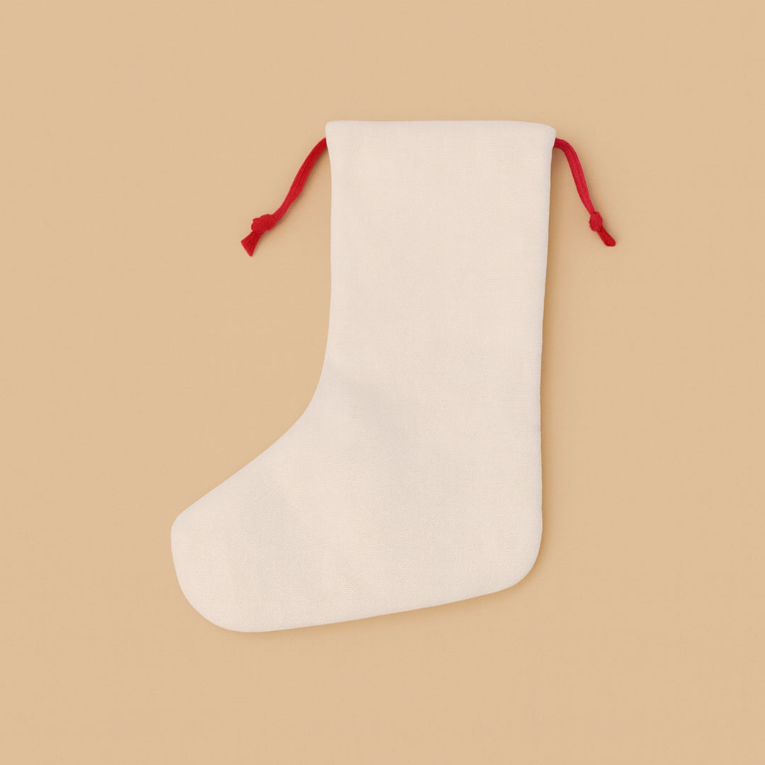 Personalized holiday stocking in cream color with red drawstring for festive decoration