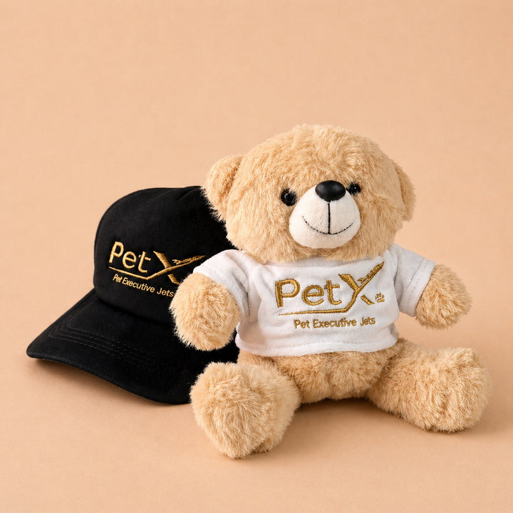Custom teddy bear with shirt featuring PetX branding beside a black cap for pet lovers