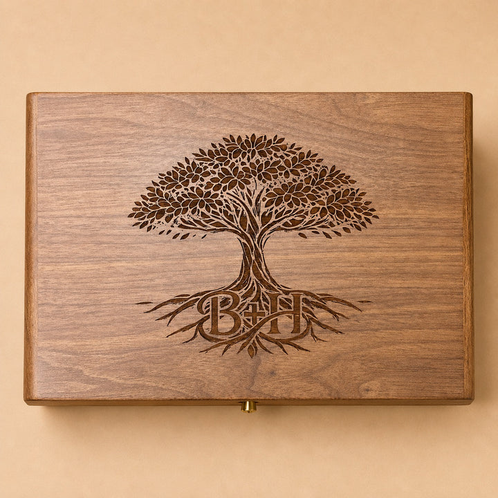 A rectangular wooden keepsake box with a laser-engraved tree of life design and the initials &