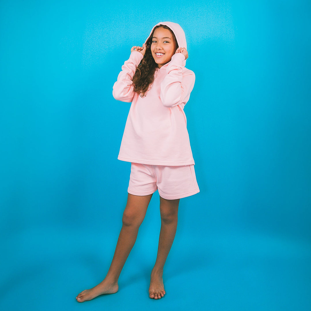 Girl wearing pink children's fashion hoodie set with long sleeve hoodie and matching shorts