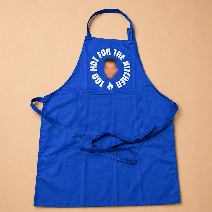Bright blue custom apron with the phrase Too Hot for the Kitchen and adjustable neck strap