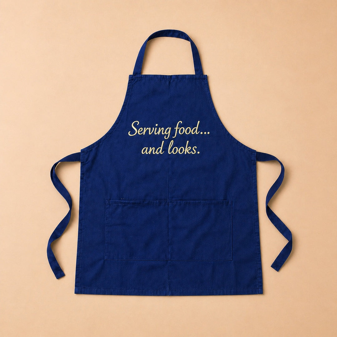 Custom apron in navy blue with the phrase Serving food... and looks for cooking enthusiasts