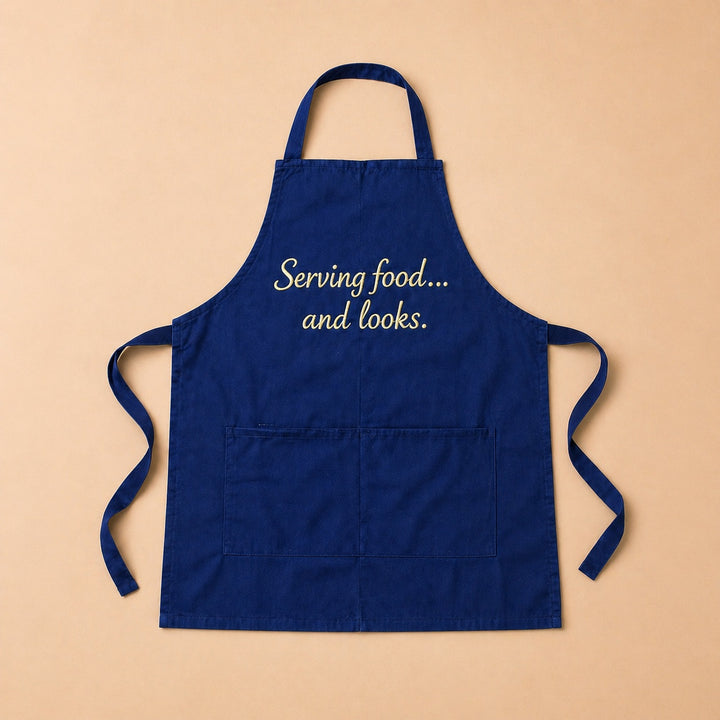 Custom apron in navy blue with the phrase Serving food... and looks for cooking enthusiasts