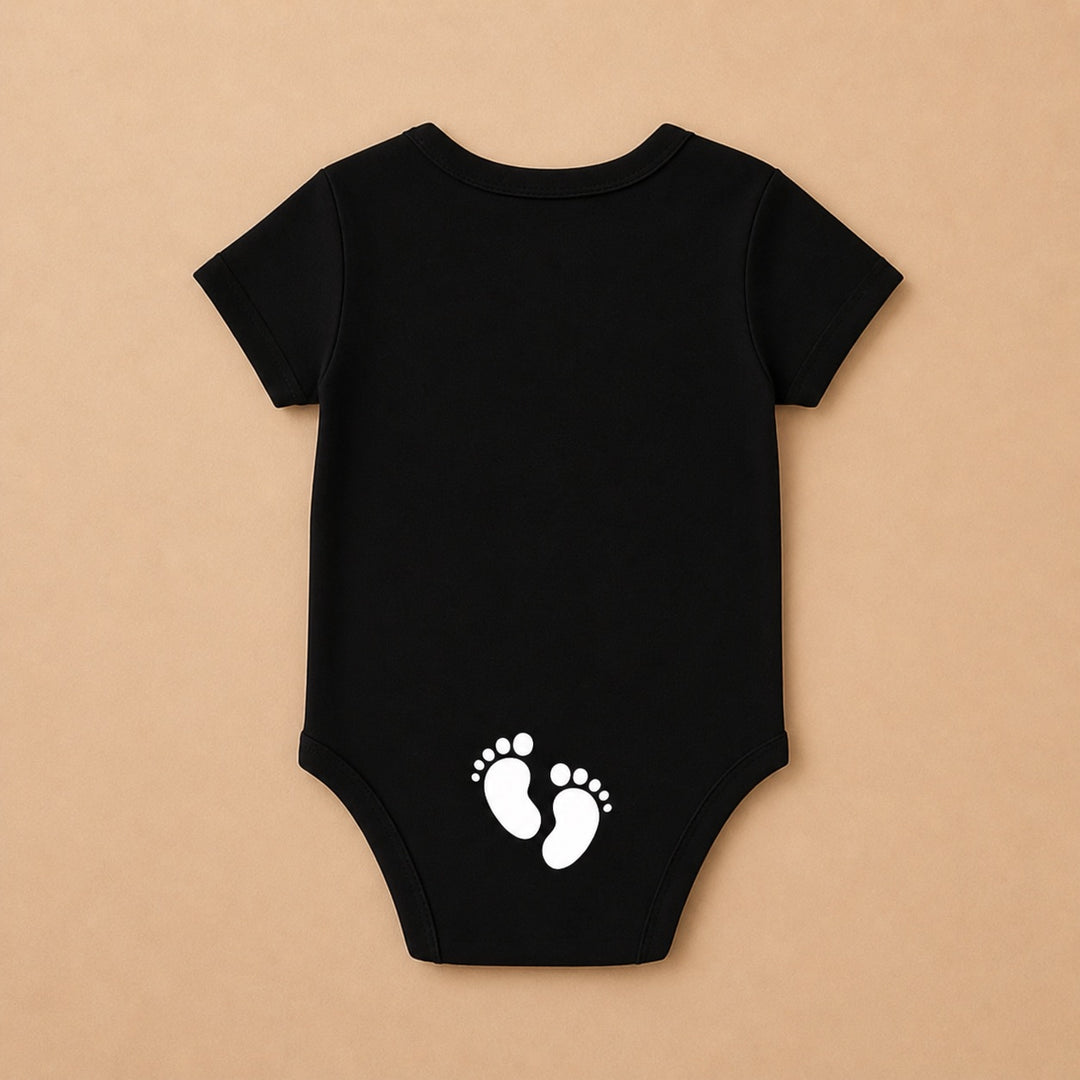 Custom baby onesie in black featuring adorable white footprint design on the back