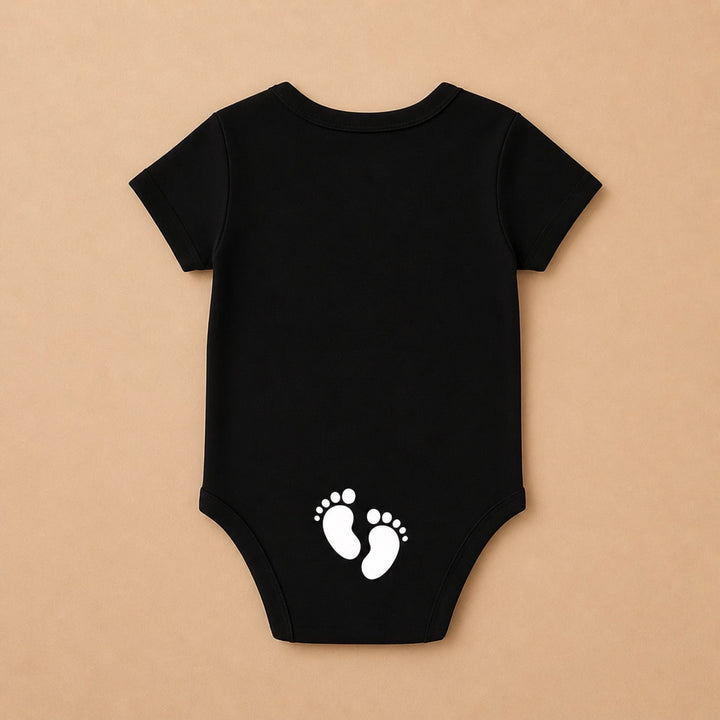 Custom baby onesie in black featuring adorable white footprint design on the back