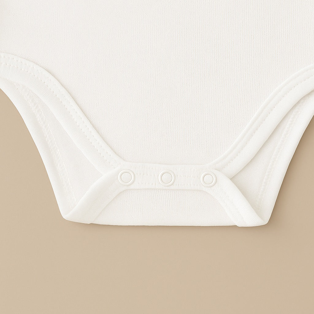 Close-up of a white custom baby tee onesie featuring soft fabric and snap buttons