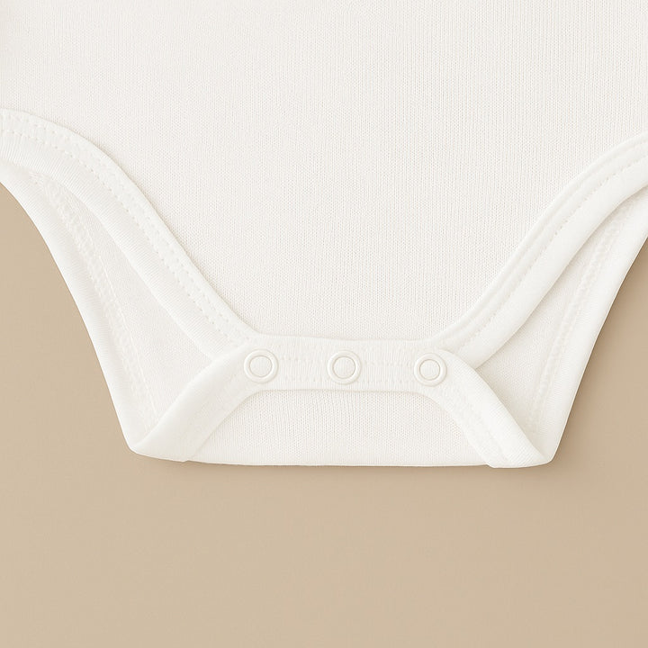 Close-up of a white custom baby tee onesie featuring soft fabric and snap buttons