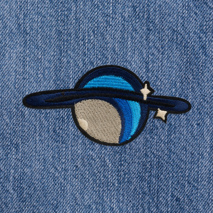 Custom embroidery service Dubai featuring a colorful planet patch on denim fabric