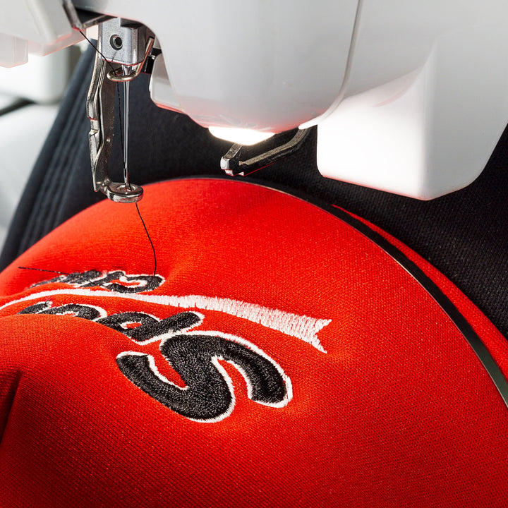 Close-up of custom embroidery service Dubai on a red cap showcasing detailed stitching