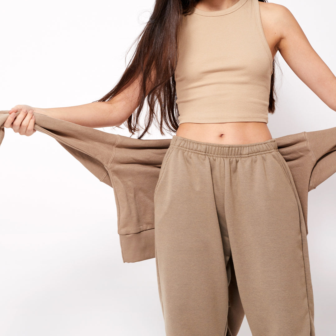 Stylish custom joggers for men and women in beige with a matching crop top for a trendy look