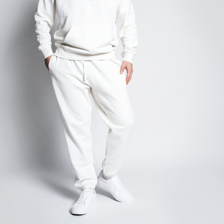 Custom joggers for men and women in soft white fabric with side pockets and elastic waistband