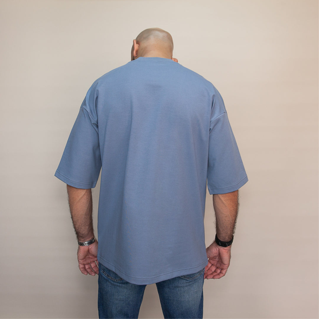 Back view of a man wearing a custom oversized tee in blue with relaxed fit for comfort
