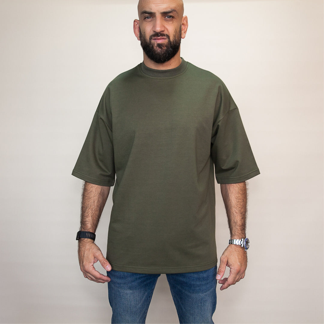 Man wearing a custom oversized tee in olive green, featuring a relaxed fit and short sleeves