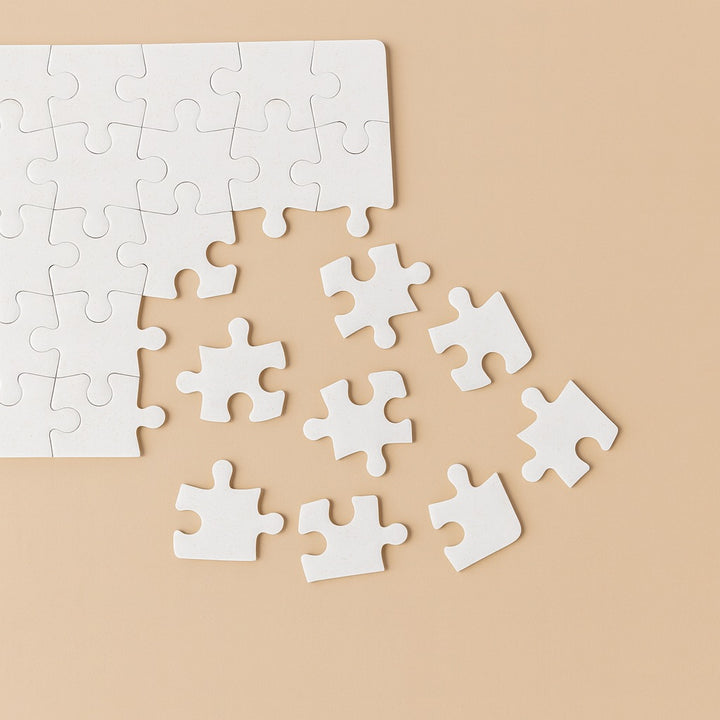 Blank pieces of a custom photo puzzle on a beige background for personalized gifting