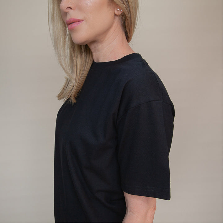 Side view of a woman wearing a black custom relaxed fit t-shirt designed for comfort and style