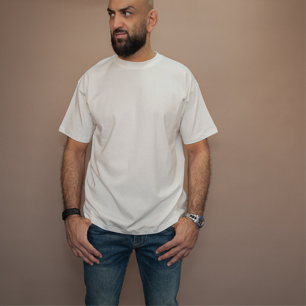 Model wearing a custom relaxed fit t-shirt in white, paired with blue jeans for a casual look
