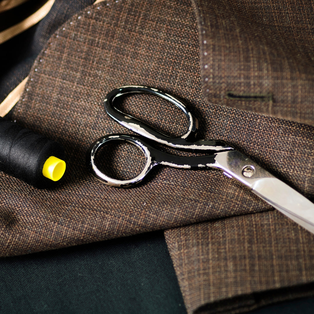 High-quality scissors and thread on custom fabric showcasing a custom tailoring service Dubai