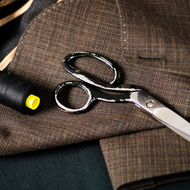 High-quality scissors and thread on custom fabric showcasing a custom tailoring service Dubai