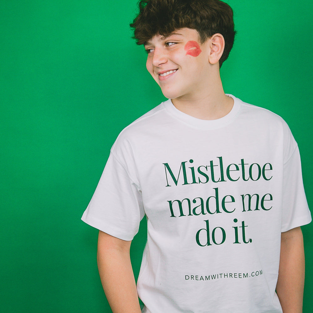 Custom holiday party graphic tee with 'Mistletoe made me do it' text for festive celebrations