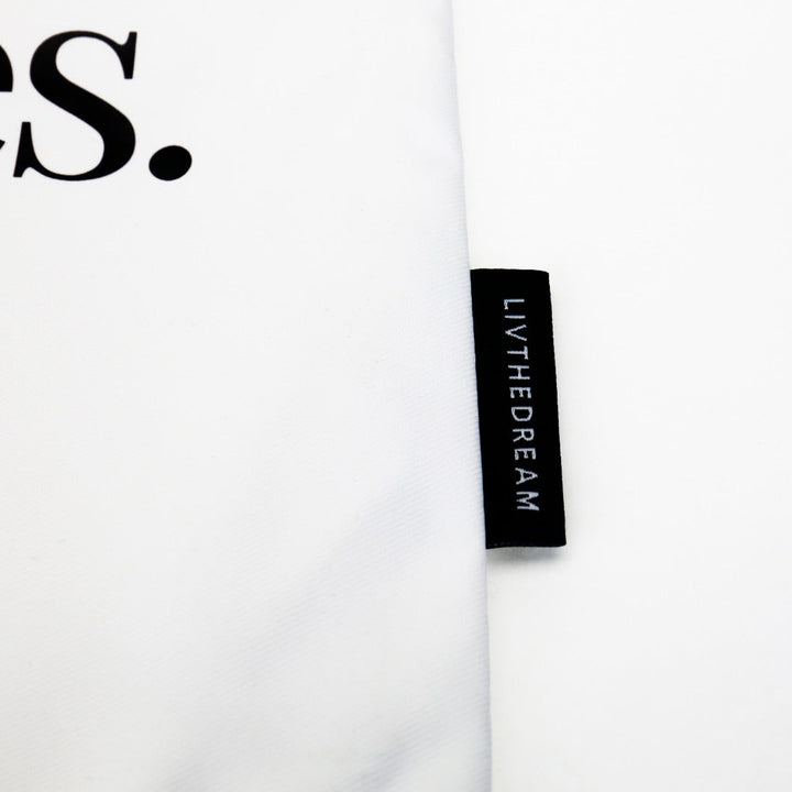 Close-up of dreamwithreem custom tote zipper pocket with LIVTHEDREAM label on white fabric