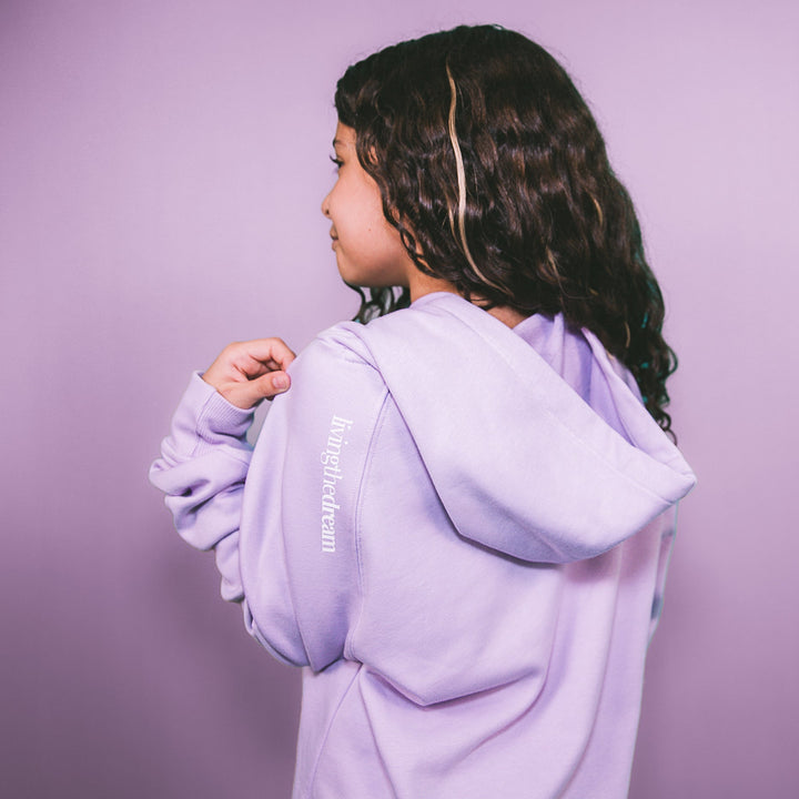 Girl wearing a personalized purple hoodie outfit from dreamwithreem shown from the back with hood up