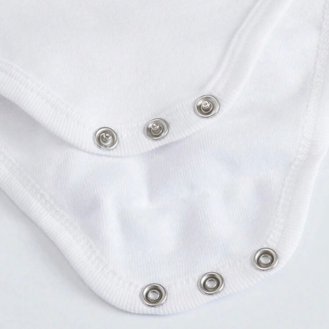 Close up of white personalized infant bodysuit showing metal snap closures and soft cotton fabric for easy diaper changes