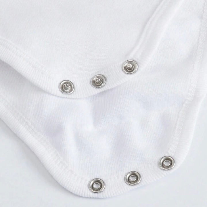 Close up of white personalized infant bodysuit showing metal snap closures and soft cotton fabric for easy diaper changes